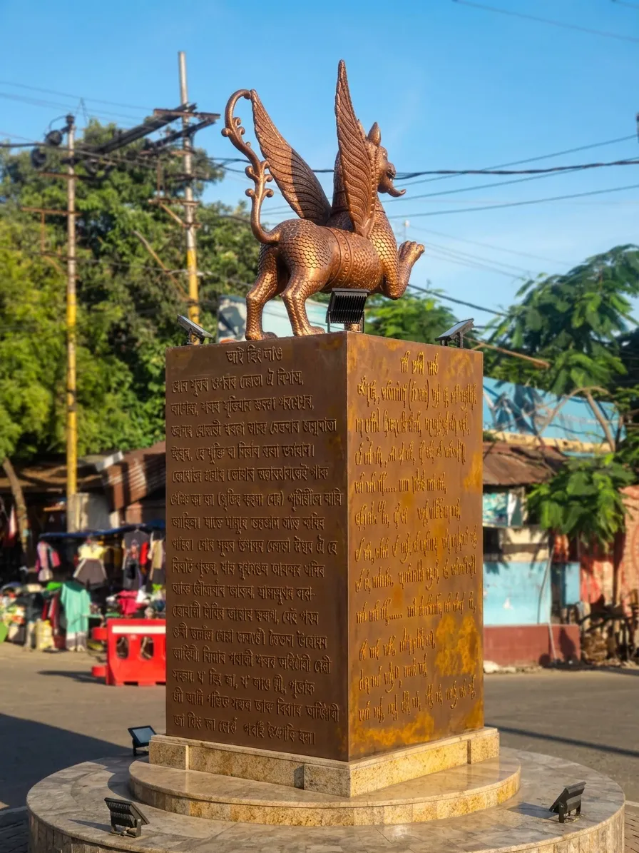The bronze Ahom dragon sculpture by daylight, seen from the back